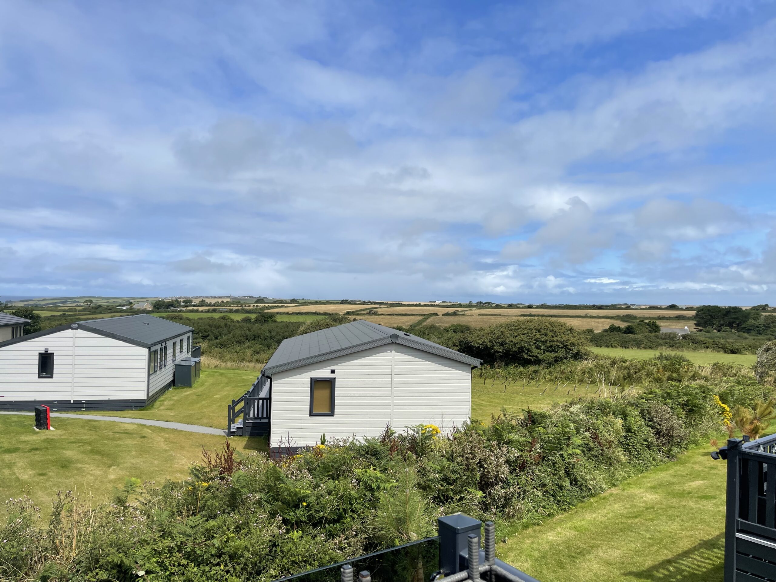 The view from the lodge across the Cornish fields under a blue sky